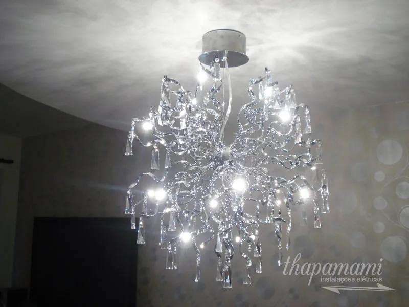 Lustre de cristal com pingentes instalado em sala de estar