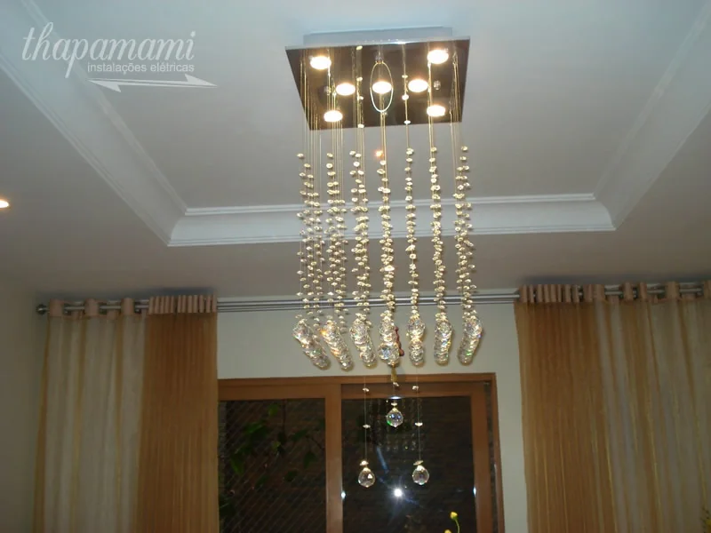 Lustre de fios de cristal instalado em ambiente de pé-direito alto